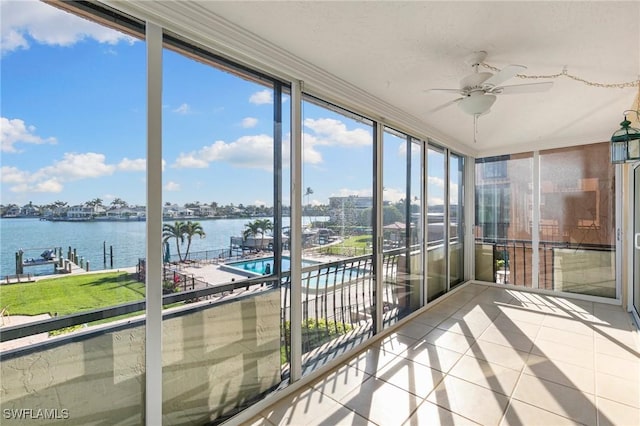 unfurnished sunroom featuring a water view and a ceiling fan