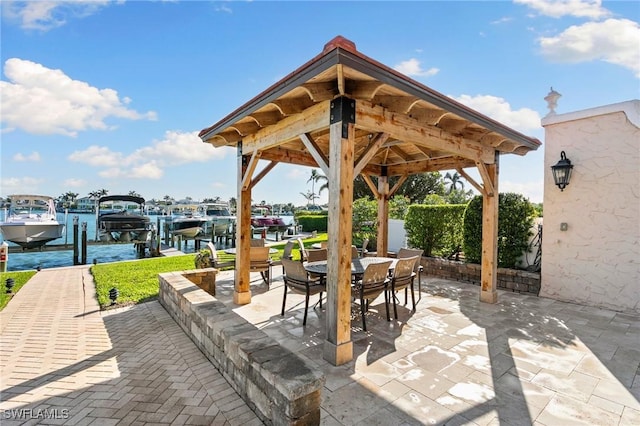 view of patio with outdoor dining space, a dock, and boat lift