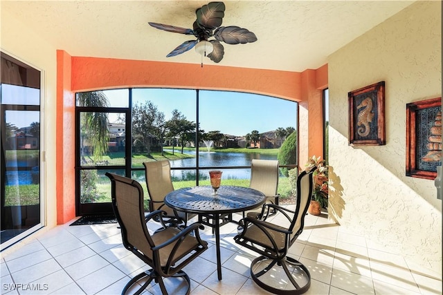 sunroom / solarium featuring a wealth of natural light, a water view, and ceiling fan