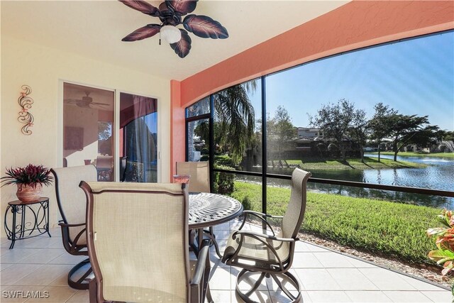 sunroom featuring a water view and ceiling fan