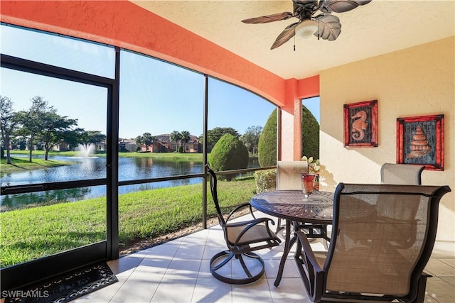 sunroom / solarium featuring a water view and ceiling fan