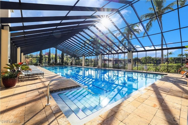 view of pool featuring glass enclosure and a patio area