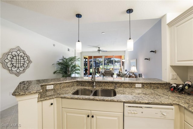 kitchen with white dishwasher, sink, ceiling fan, light stone countertops, and kitchen peninsula