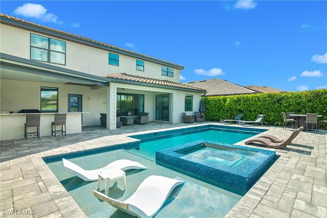 view of swimming pool with an in ground hot tub, exterior bar, an outdoor living space, and a patio