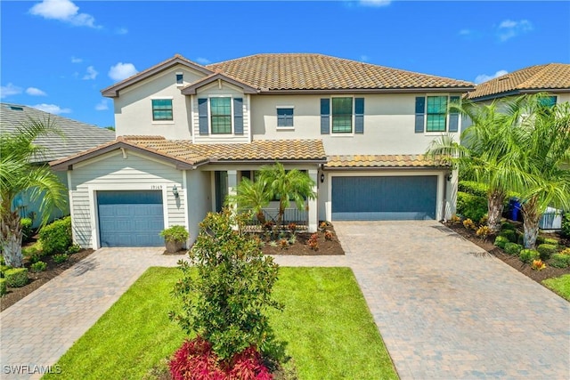 mediterranean / spanish-style home featuring a front yard and a garage