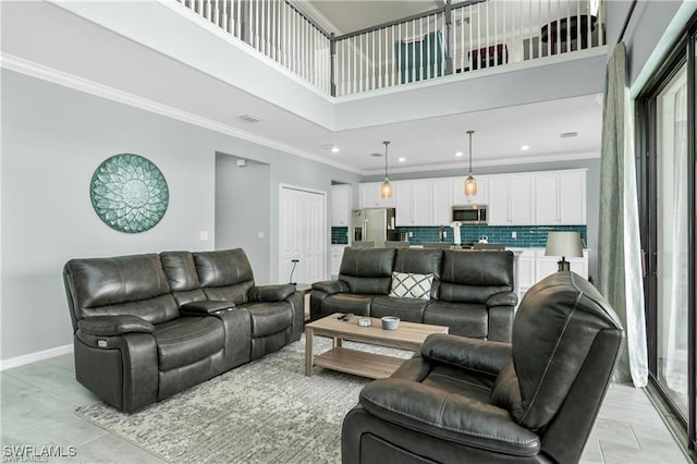 living room featuring a towering ceiling and ornamental molding