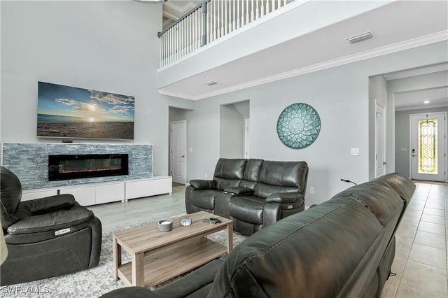 tiled living room with a tile fireplace and ornamental molding