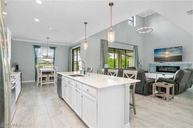 kitchen with white cabinets, dishwasher, sink, a center island with sink, and a breakfast bar area