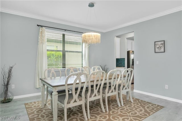 dining area with light wood-type flooring and crown molding