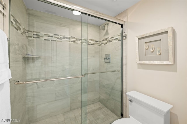 bathroom featuring a stall shower and toilet