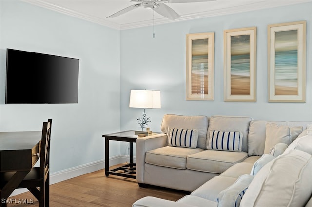 living area with ceiling fan, crown molding, baseboards, and wood finished floors