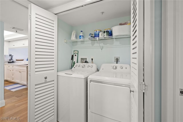 laundry area featuring laundry area, independent washer and dryer, and light wood finished floors