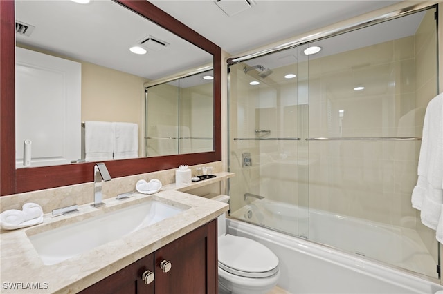 bathroom with toilet, shower / bath combination with glass door, vanity, and visible vents