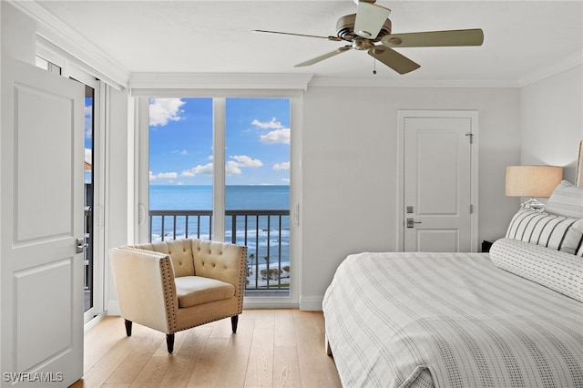 bedroom featuring access to exterior, crown molding, light wood finished floors, a water view, and multiple windows