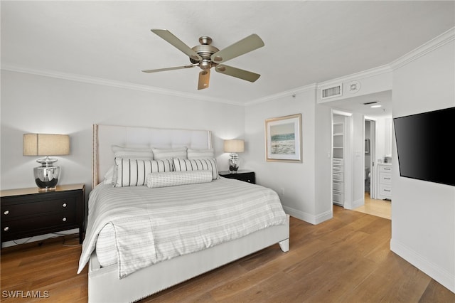 bedroom featuring baseboards, visible vents, wood finished floors, and ornamental molding