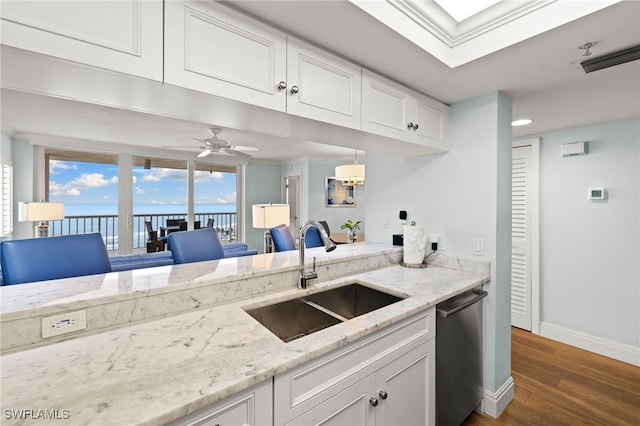 kitchen with a sink, white cabinetry, baseboards, dishwasher, and dark wood finished floors