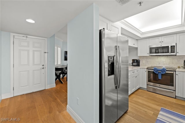 kitchen featuring appliances with stainless steel finishes, light countertops, light wood-style floors, and white cabinetry