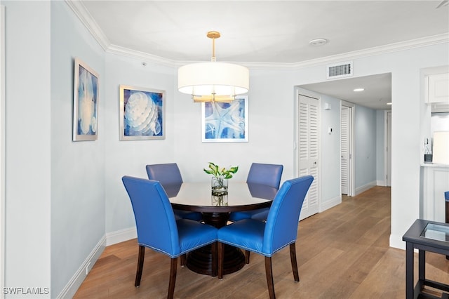 dining space featuring crown molding, visible vents, and wood finished floors