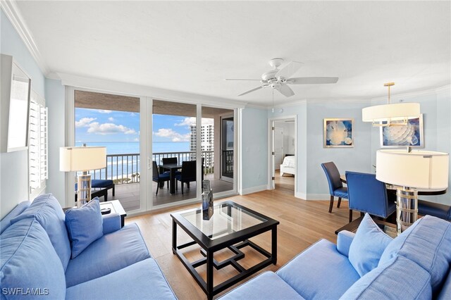 living room featuring crown molding, a water view, and light wood-type flooring