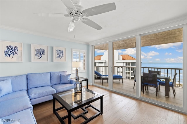 sunroom with ceiling fan and a water view