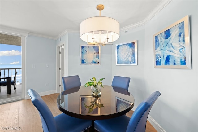 dining room featuring baseboards, crown molding, an inviting chandelier, and wood finished floors