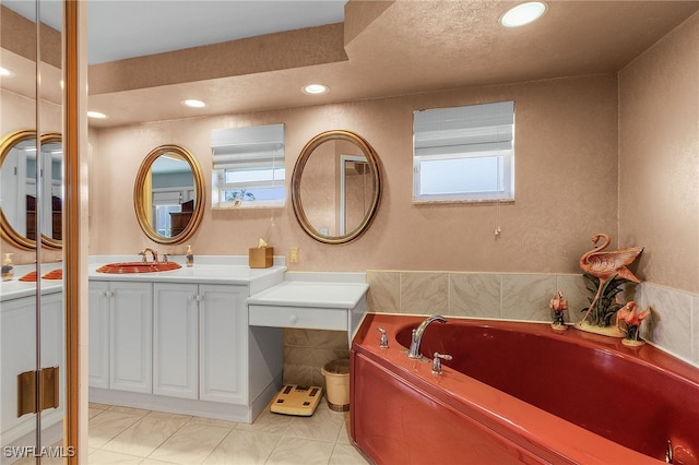 bathroom with tile patterned flooring, vanity, and a tub to relax in