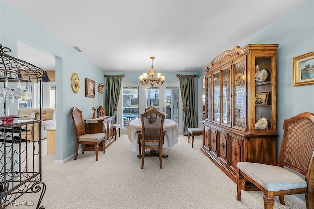 carpeted dining space featuring an inviting chandelier