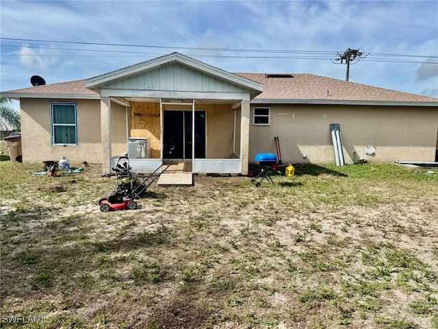 rear view of property with a yard and a sunroom