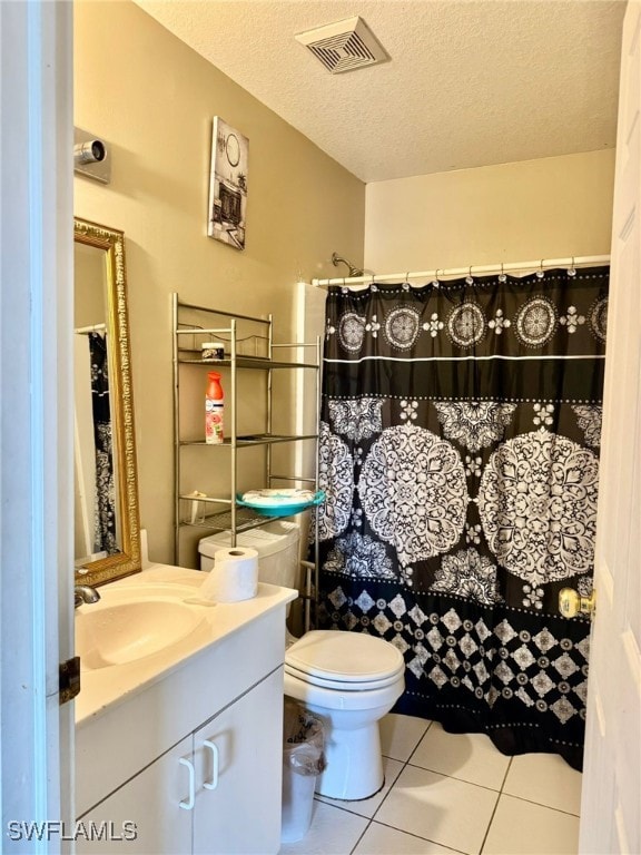 bathroom featuring toilet, vanity, tile patterned flooring, a shower with curtain, and a textured ceiling