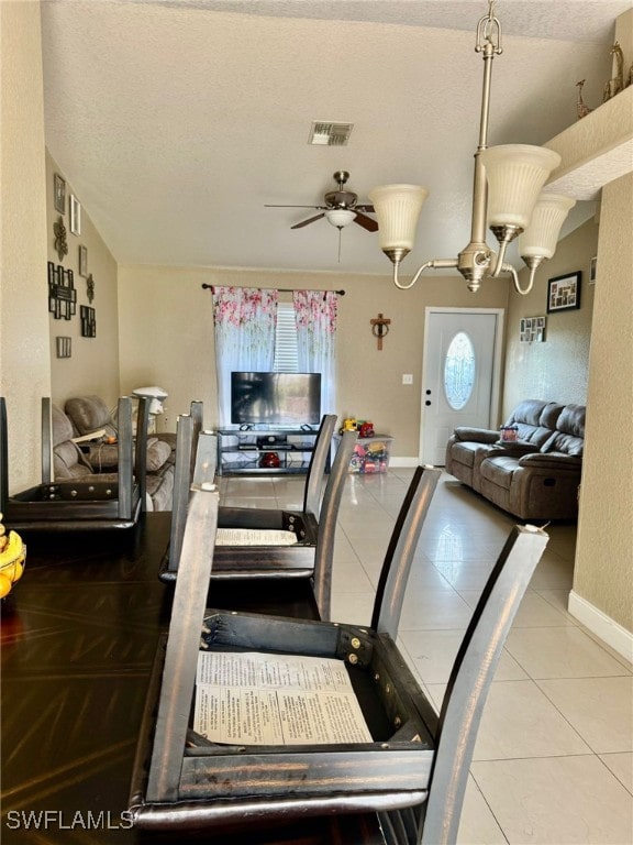 dining room featuring a textured ceiling, ceiling fan with notable chandelier, and tile patterned floors