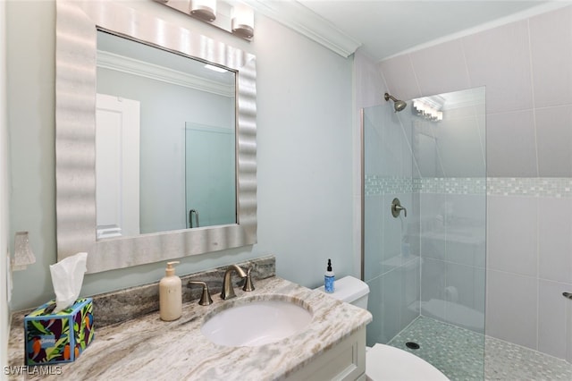 bathroom with a tile shower, vanity, toilet, and crown molding