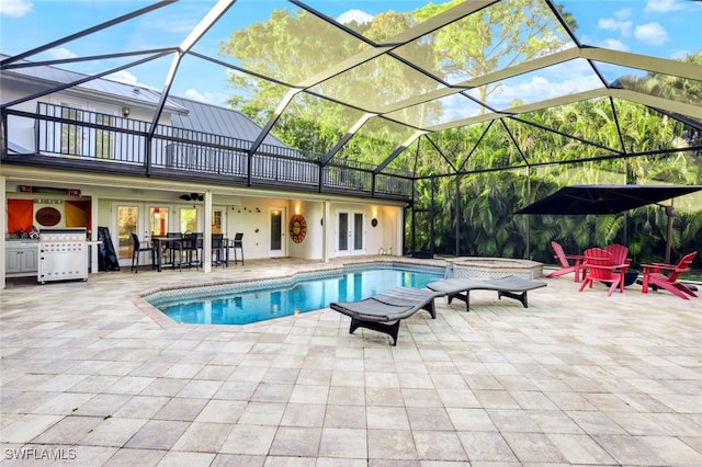 view of pool featuring glass enclosure, ceiling fan, a patio area, and french doors