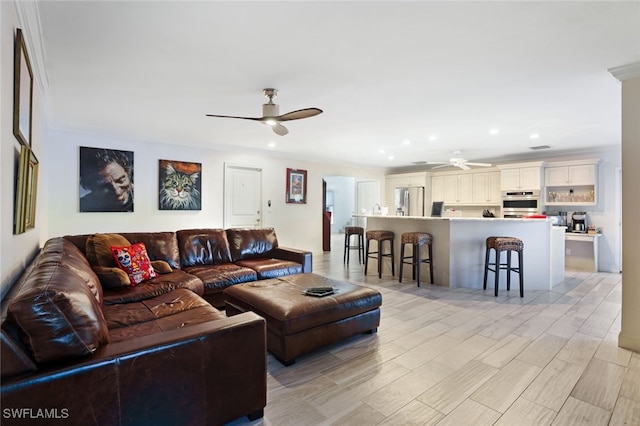 living room with ceiling fan, light hardwood / wood-style floors, and crown molding