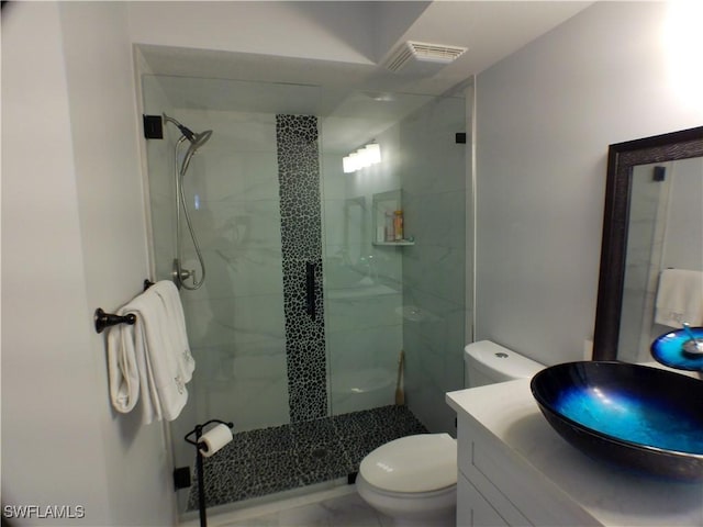 bathroom with vanity, a shower with shower door, and toilet