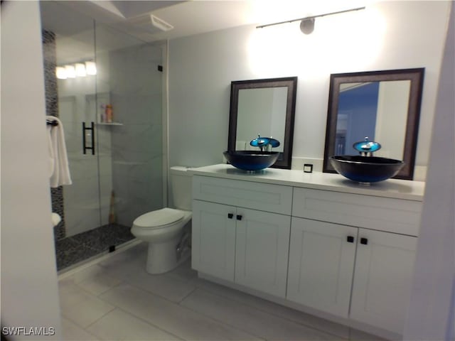 bathroom featuring toilet, tile patterned flooring, vanity, and walk in shower