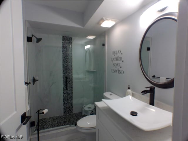 bathroom featuring tiled shower, tile patterned floors, vanity, and toilet