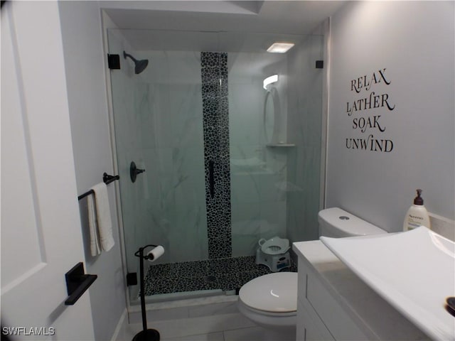 bathroom with toilet, vanity, tile patterned floors, and a shower with shower door