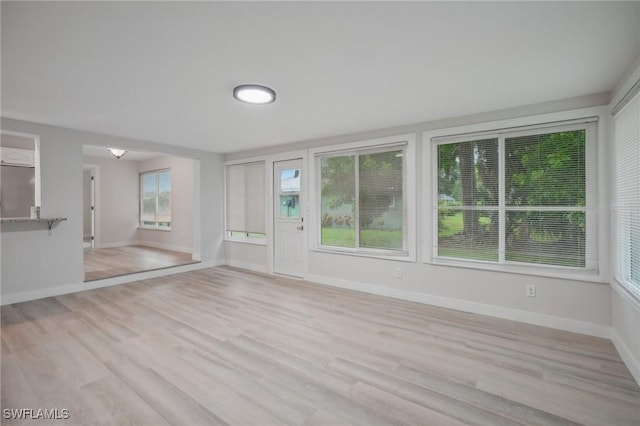 unfurnished living room with a wealth of natural light and light hardwood / wood-style flooring