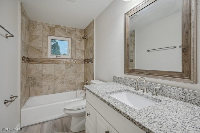 full bathroom featuring toilet, vanity, wood-type flooring, and tiled shower / bath combo