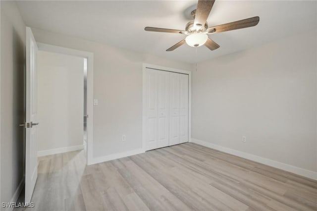 unfurnished bedroom with ceiling fan, a closet, and light wood-type flooring