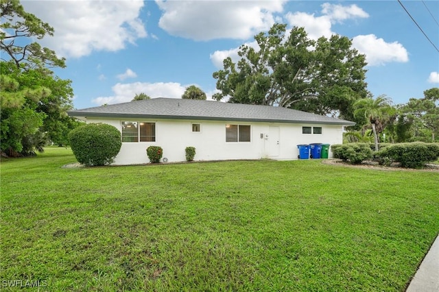 rear view of house featuring a yard