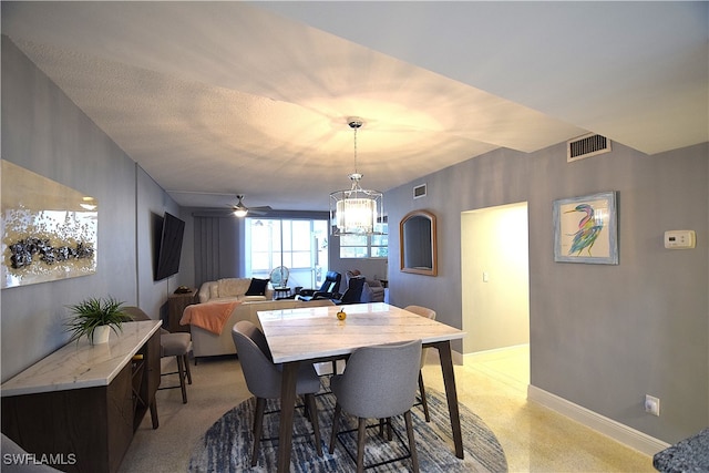 dining space with ceiling fan with notable chandelier