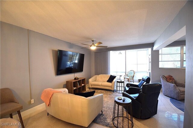 living room with ceiling fan and a textured ceiling