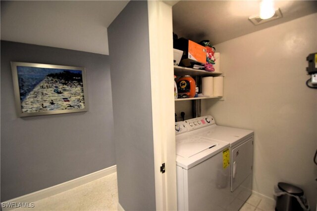 clothes washing area with light tile patterned floors and separate washer and dryer