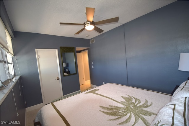 carpeted bedroom with a textured ceiling and ceiling fan