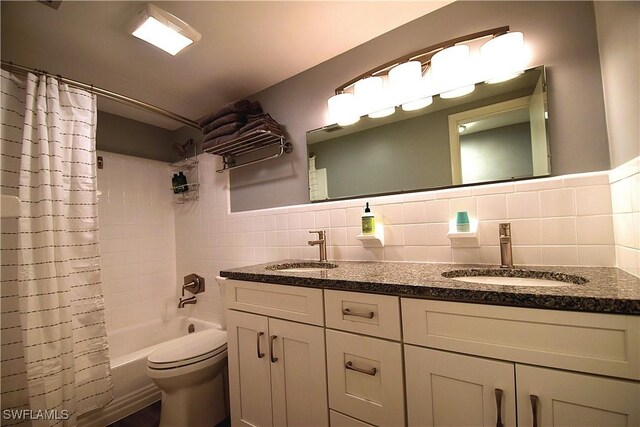 full bathroom with vanity, toilet, shower / bath combo with shower curtain, and tile walls