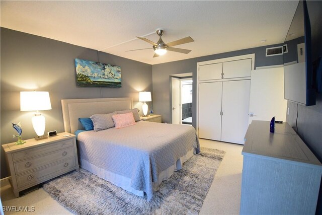 carpeted bedroom with ceiling fan and a closet