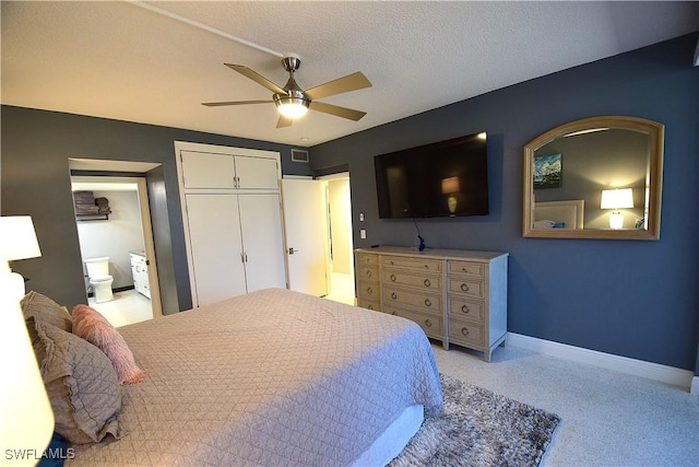 bedroom featuring ceiling fan, a textured ceiling, connected bathroom, and a closet