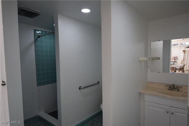 bathroom featuring tiled shower, vanity, and toilet