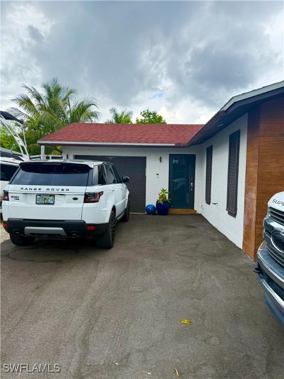 4207 Cindy Ave, Naples, FL 34112 - exterior space featuring stucco siding, driveway, and a garage